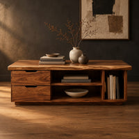 Live edge coffee table with two drawers an open shelf and a side cubby in a dark studio against a charcoal plaster wall