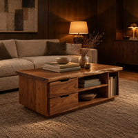 Live edge coffee table with two drawers an open shelf and a side cubby in an evening living room with walnut wall paneling