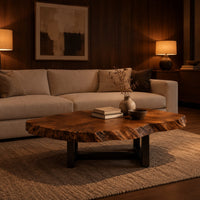 Live edge coffee table with a wide irregular slab top on a dark frame in an evening living room with walnut wall paneling