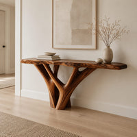 Console table with a live edge slab top on a branching trunk base in a Scandinavian entryway with white walls
