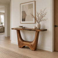 Live edge console table with a u shaped base and a low arched foot in a Scandinavian entryway with white walls
