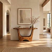 Live edge console table with a u shaped base and a low arched foot in a bright open plan entryway