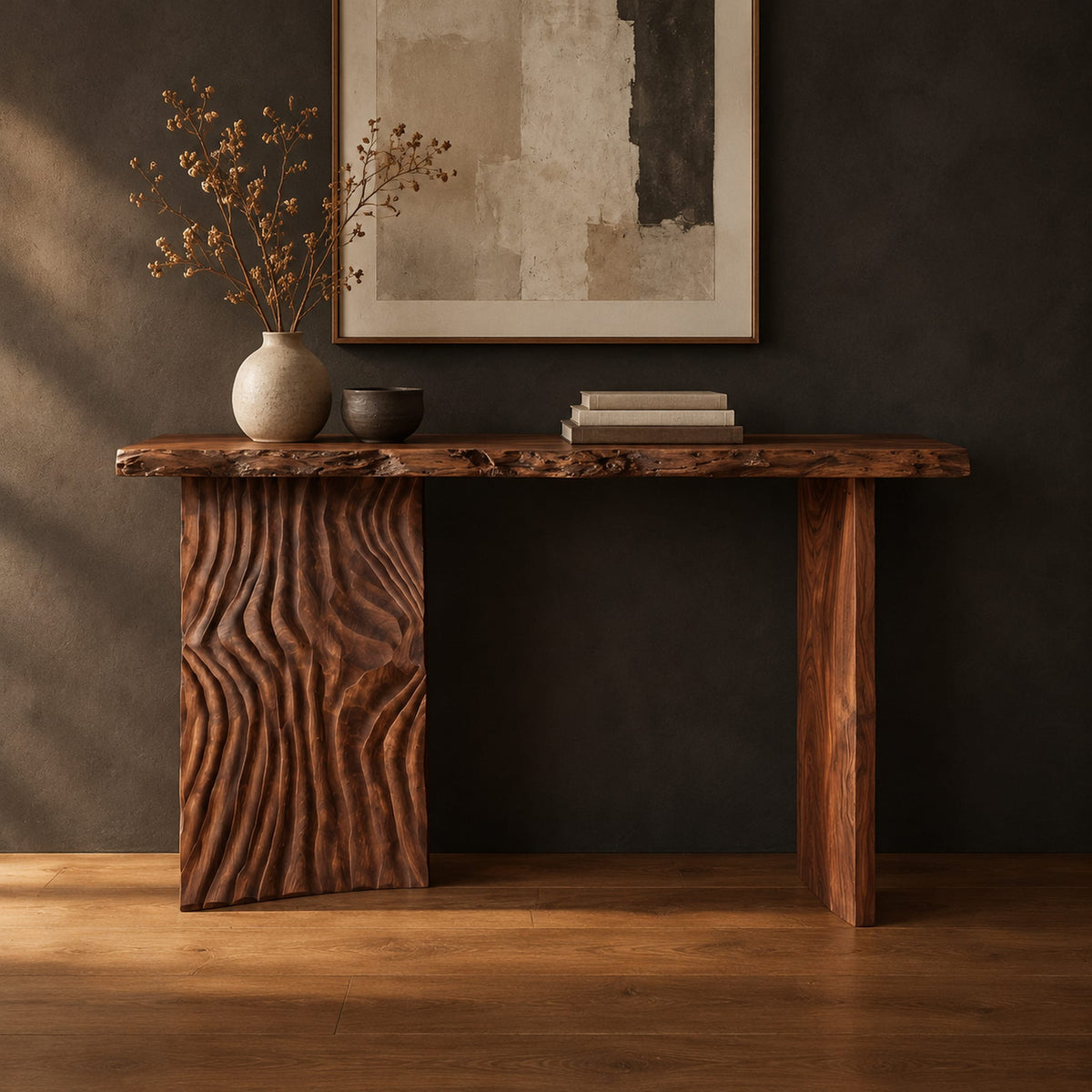 Live edge console table with a carved ripple slab leg in a dark studio against a charcoal plaster wall