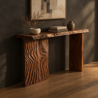 Live edge console table with a carved ripple slab leg, three-quarter view showing the grain