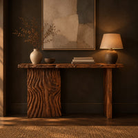 Live edge console table with a carved ripple slab leg in a dark entryway at golden hour