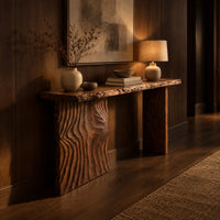Live edge console table with a carved ripple slab leg in an evening entryway with walnut wall paneling