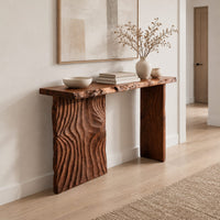 Live edge console table with a carved ripple slab leg in a Scandinavian entryway with white walls