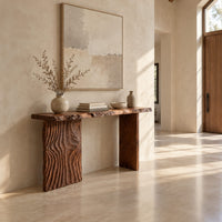 Live edge console table with a carved ripple slab leg in a bright open plan entryway