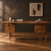 Live edge wooden desk with four drawers and slim tapered legs in a dark studio against a charcoal plaster wall