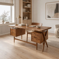 Live edge wooden desk with four drawers and slim tapered legs in a Scandinavian home office with white walls