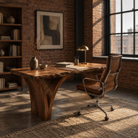 Live edge desk on two arched slab legs that flare toward the top in an industrial loft home office with exposed brick