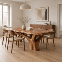 Live edge dining table on a branching tree trunk base in a Scandinavian dining room with white walls