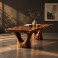 Live edge dining table on two forked trunk pedestals, three-quarter view showing the grain