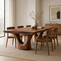 Live edge dining table on two forked trunk pedestals in a Scandinavian dining room with white walls