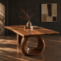 Live edge dining table on a large open ring pedestal base, three-quarter view showing the grain