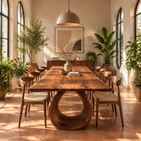 Live edge dining table on a large open ring pedestal base in a bright dining room with arched windows and plants