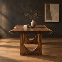 Live edge dining table with a slab top and arch cutout legs in a dark studio against a charcoal plaster wall