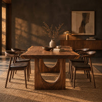 Live edge dining table with a slab top and arch cutout legs in a dark dining room at golden hour