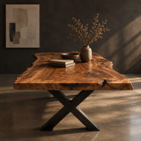 Live edge dining table with a black x shaped base, three-quarter view showing the grain