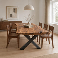 Live edge dining table with a black x shaped base in a Scandinavian dining room with white walls