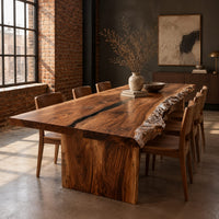 Live edge dining table with a dark center seam and a slab base in an industrial loft dining room with exposed brick