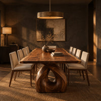 Live edge dining table on a single sculpted pedestal with a teardrop opening in a dark dining room at golden hour