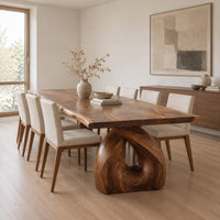 Live edge dining table on a single sculpted pedestal with a teardrop opening in a Scandinavian dining room with white walls