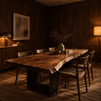 Live edge slab dining table on two open rectangular block legs in an evening dining room with walnut wall paneling