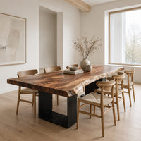 Live edge slab dining table on two open rectangular block legs in a Scandinavian dining room with white walls