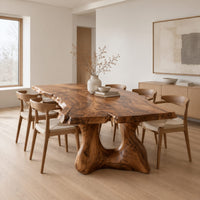 Live edge dining table with a thick top and a sculpted arched base in a Scandinavian dining room with white walls