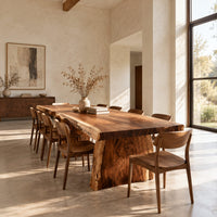 Live edge dining table with a thick slab top and tapered block base in a bright open plan dining room