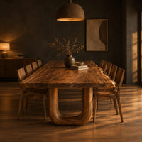 Live edge dining table on two thick u shaped legs in a dark dining room at golden hour