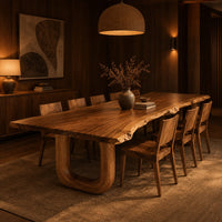 Live edge dining table on two thick u shaped legs in an evening dining room with walnut wall paneling