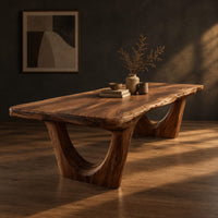 Live edge wooden dining table on two arched pedestal legs, three-quarter view showing the grain