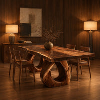 Rectangular dining table with a live edge slab top and two loop pedestals in an evening dining room with walnut wall paneling