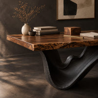 Corner detail of live edge desk with a dark sculpted wave shaped base beside wood, brass and linen samples