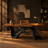 Live edge desk with a dark sculpted wave shaped base in a dark home office at golden hour