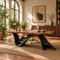 Live edge desk with a dark sculpted wave shaped base in a bright home office with arched windows and plants