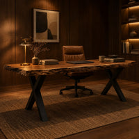 Live edge desk with a natural slab top and black crossed legs in an evening home office with walnut wall paneling