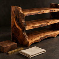Corner detail of open shoe shelf with three tiers and natural live edge sides beside wood, brass and linen samples