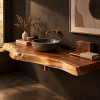 Corner detail of thick live edge wood slab with natural wavy edge and open space below beside wood, brass and linen samples