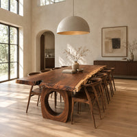 Long live edge slab dining table on thick ring shaped bases in a bright open plan dining room