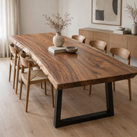 Thick wooden slab table top with a wavy natural edge and swirling grain in a Scandinavian dining room with white walls