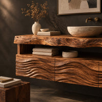 Corner detail of wall hung cabinet with live edge top, open shelf and wave carved front beside wood, brass and linen samples