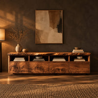 Live edge tv stand with four open cubbies above swirling grain front panels in a dark living room at golden hour