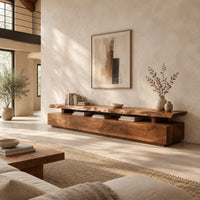Long low tv stand with a natural edge slab top over a block base in a bright open plan living room