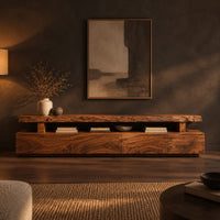 Live edge tv stand with a raised slab top and an open display gap in a dark living room at golden hour