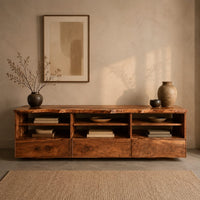 Corner detail of live edge tv stand with three open shelf bays and lower front panels beside wood, brass and linen samples