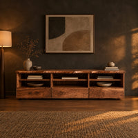 Live edge tv stand with three open shelf bays and lower front panels in a dark living room at golden hour