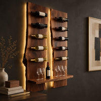 Corner detail of wine rack of two tall live edge slabs with angled bottle pegs beside wood, brass and linen samples